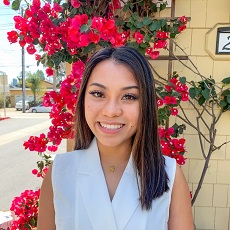 photo of Kathryn Catamura with flowering bush as backdrop