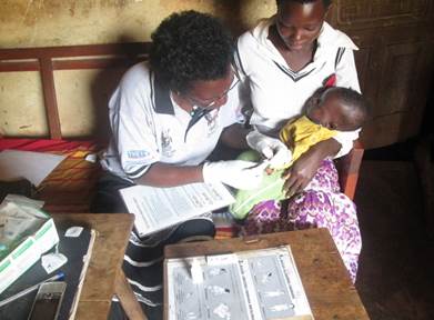 Village Health Team member in Uganda takes a blood sample from a child