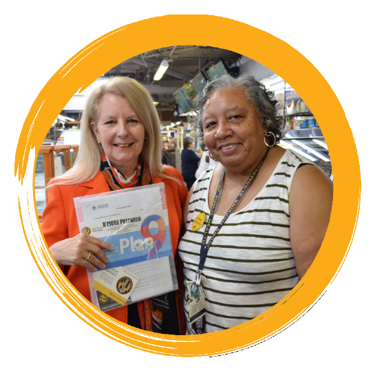 two woman posing with preparedness education pamphlet