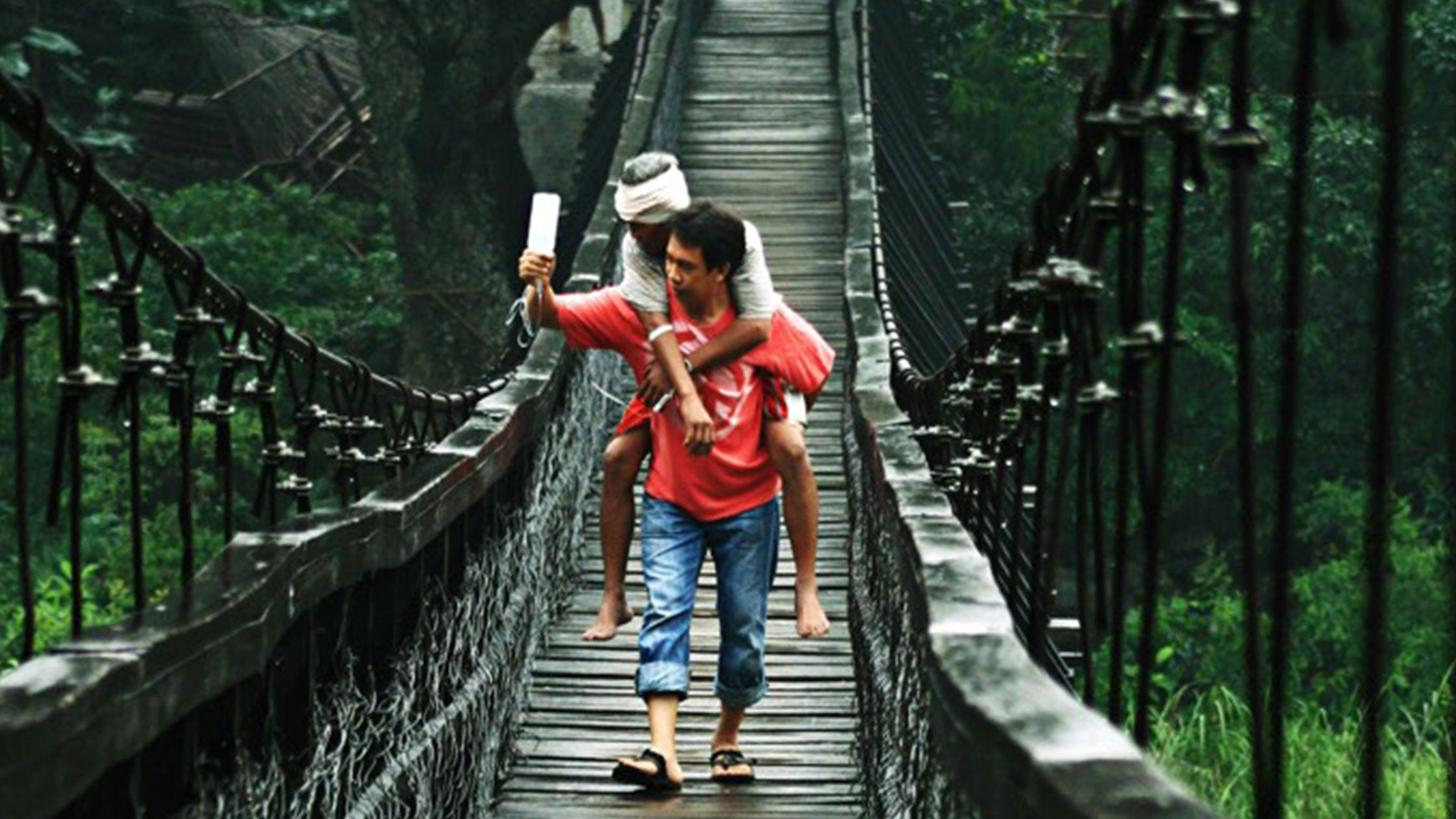 Man and woman crossing a rope bridge