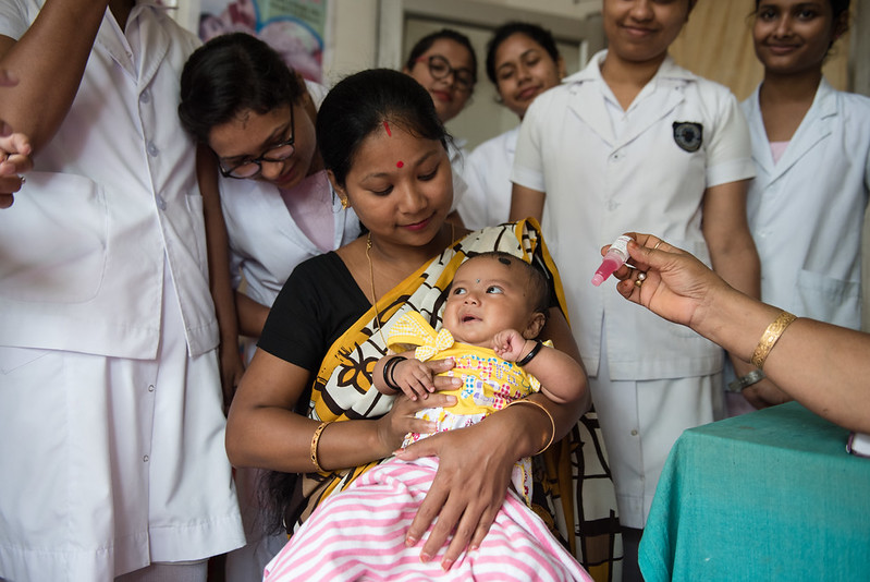 Mother holds her baby before recieving rotavirus vaccine.