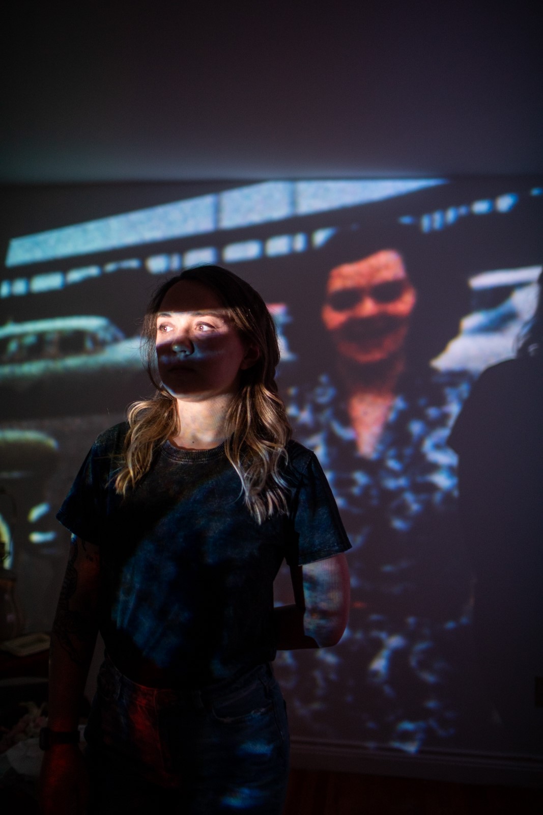 Photo of Amanda Mustard with a projected photograph of her grandmother.