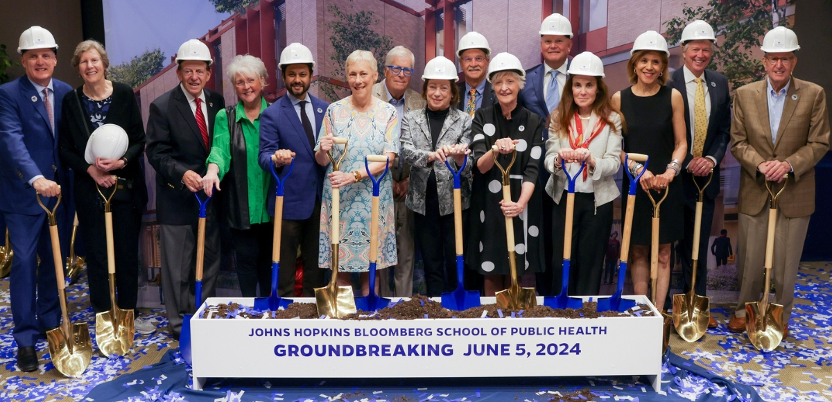 Dean Ellen MacKenzie and members of the Health Advisory Board pose on stage with shovels and hardhats at the South Building groundbreaking event