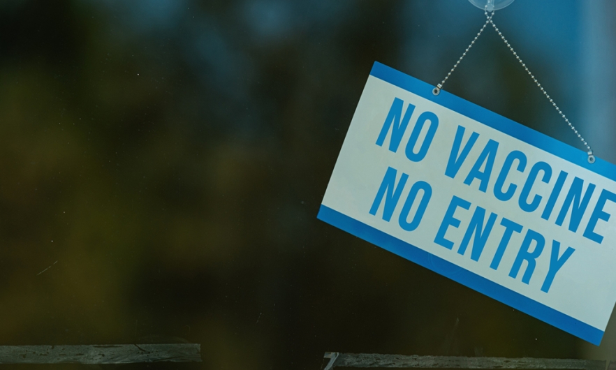 sign on a business's window that says "No vaccine, no entry"