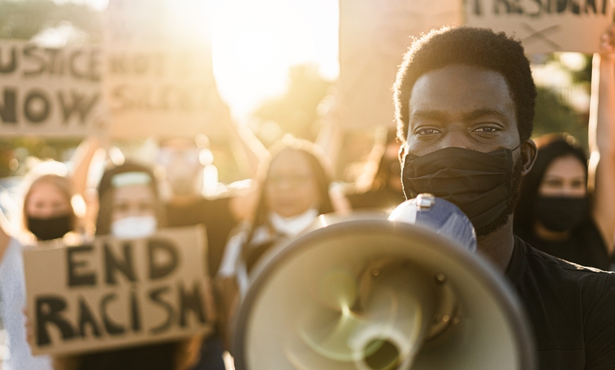 Black man holding megaphone protesting to end racism