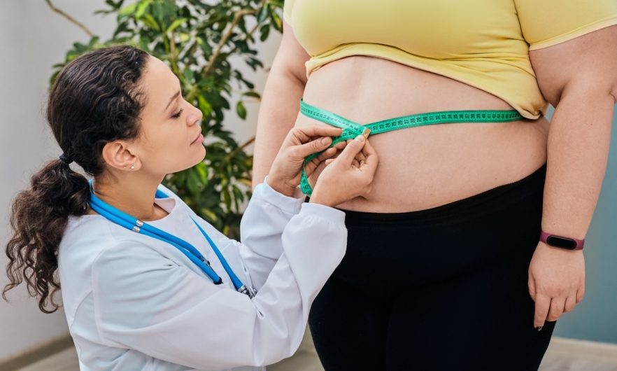 Obese woman's stomach being measured by doctor