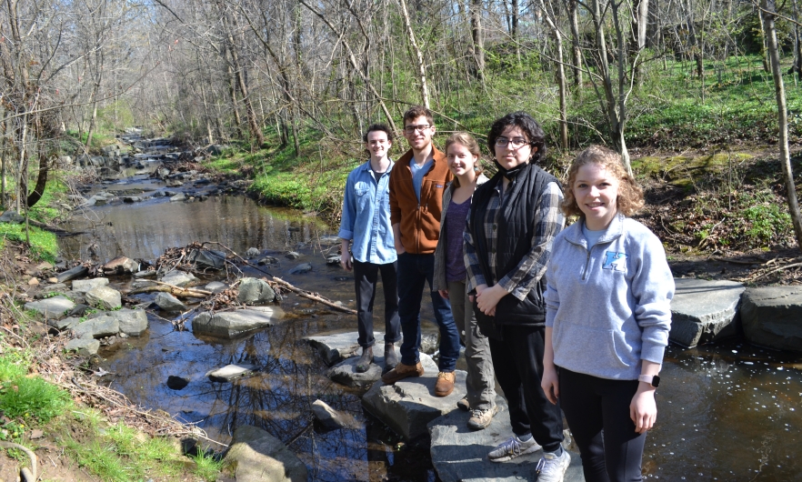Alexander Holt, Zachary Ellis, Amanda Hinton, Marissela Gomez, and Chloe Frantz stand on rocks in Stony Run Creek.