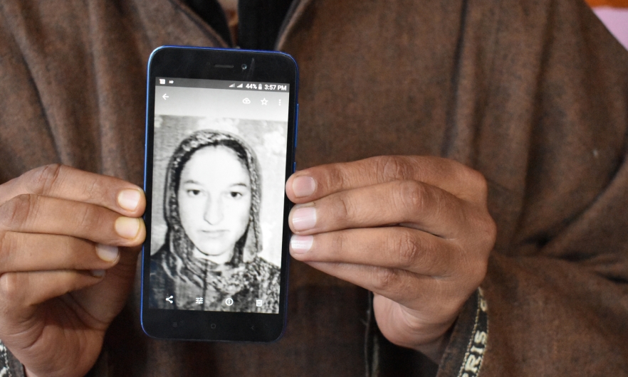 Javed Ahmed Padroo displays a photo of his wife, Ruqiya Javed, on his cellphone. Anantnag, Kashmir, April 21. Image by Aliya Bashir.