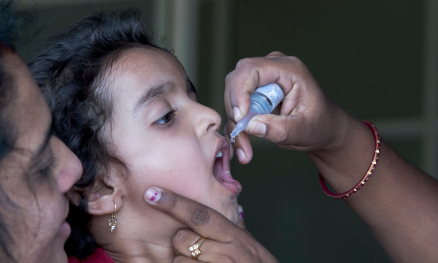 Young girl receiving liquid polio vaccine