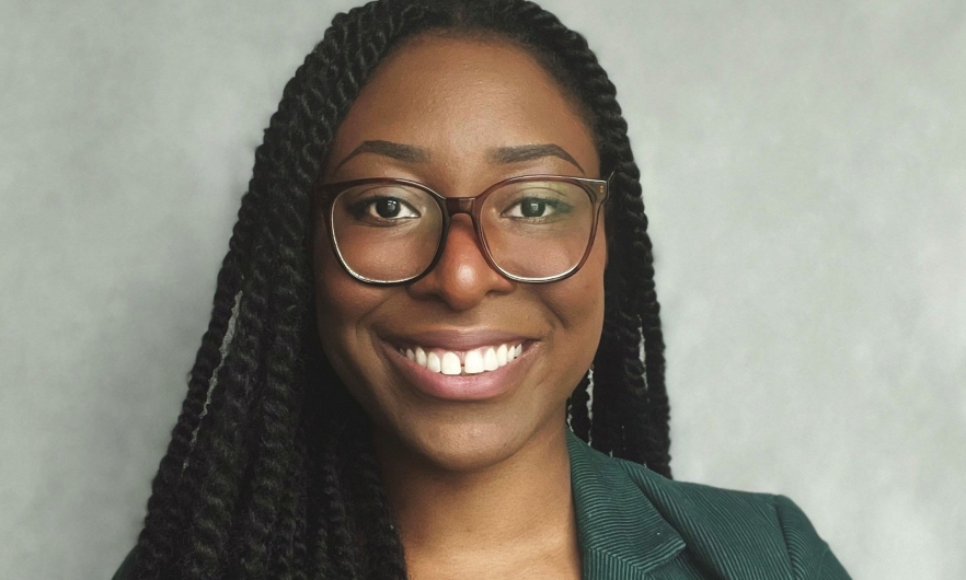 African American lady with long braids, wearing glasses, smiling