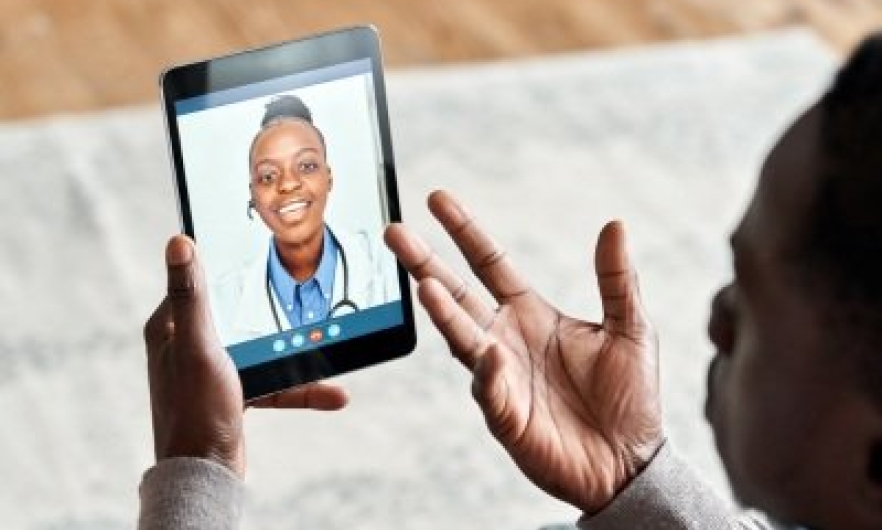Patient holding tablet speaking with doctor over videochat