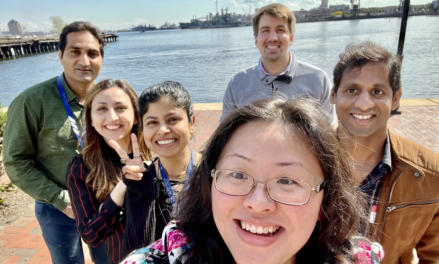 Six MMI students and lab members pose for a selfie near the water in Baltimore's historic Fells Point. 