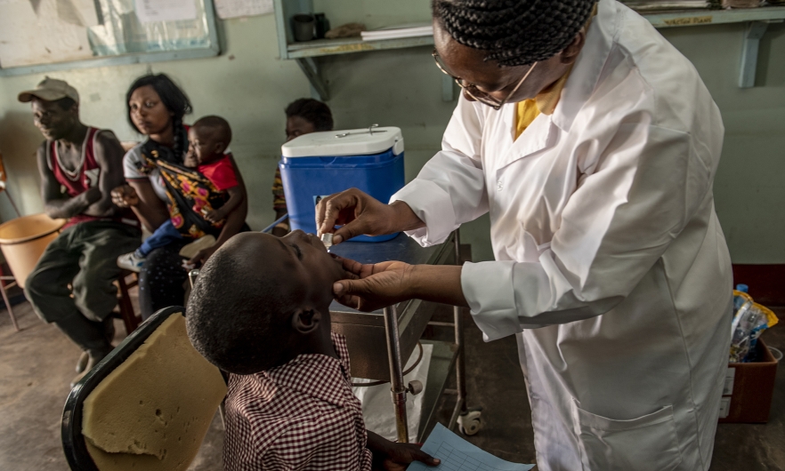 A health worker administers oral cholera vaccine to a child in Zambia.  