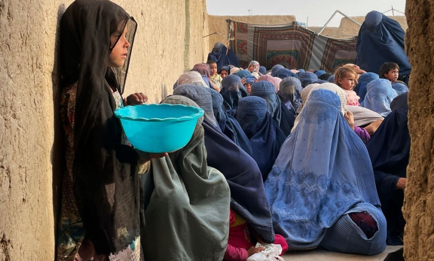 People wait to receive a food donation from the Afterlife foundation during Islam's Holy fasting month of Ramadan in Kandahar
