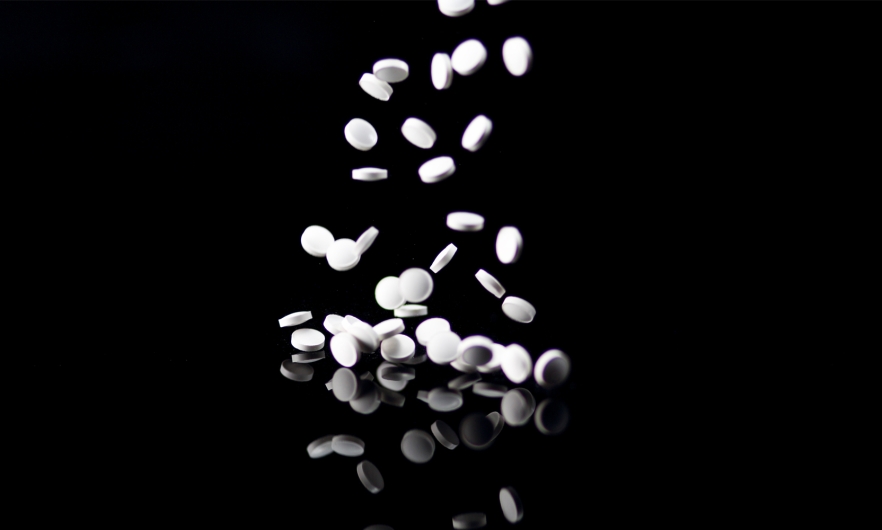 Ketamine pills fall onto a table. 