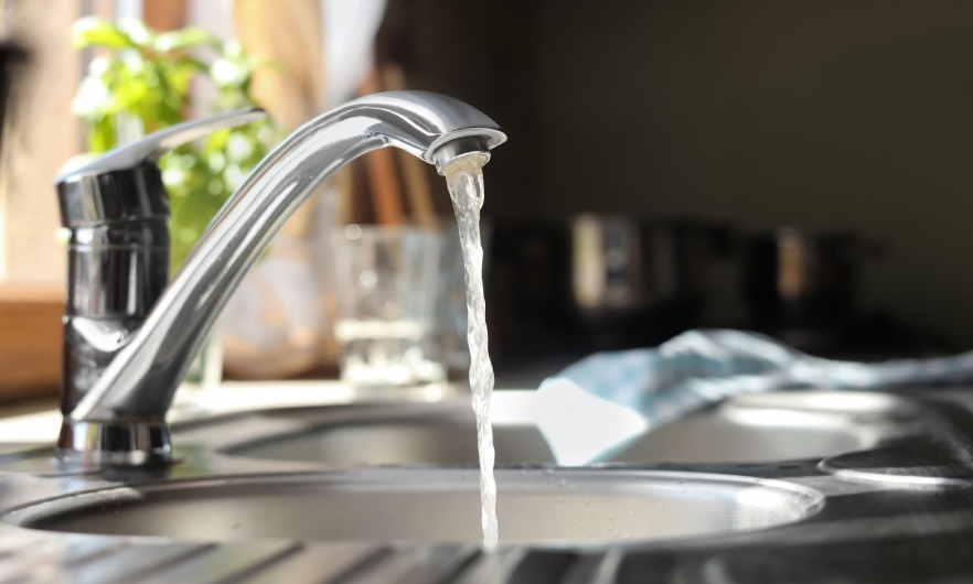 photo of a kitchen faucet with water running