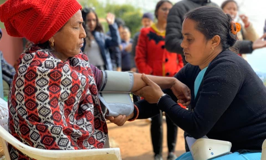 Community health worker in Nepal takes a blood pressure screening