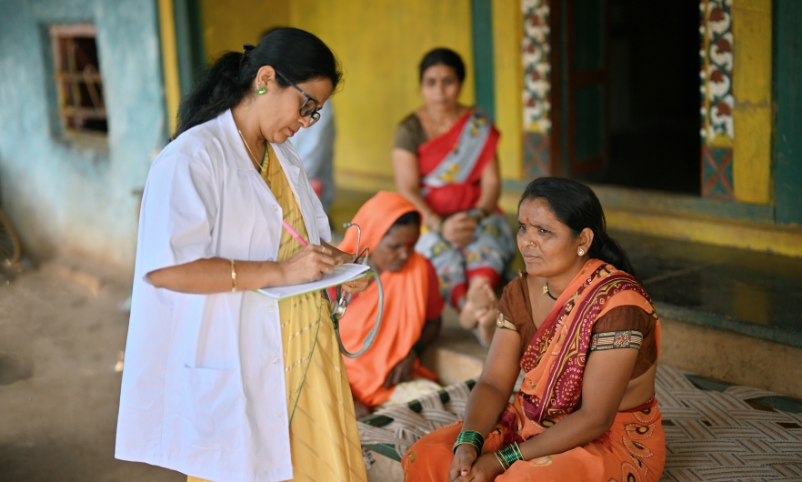 Doctor giving out prescription in rural India.