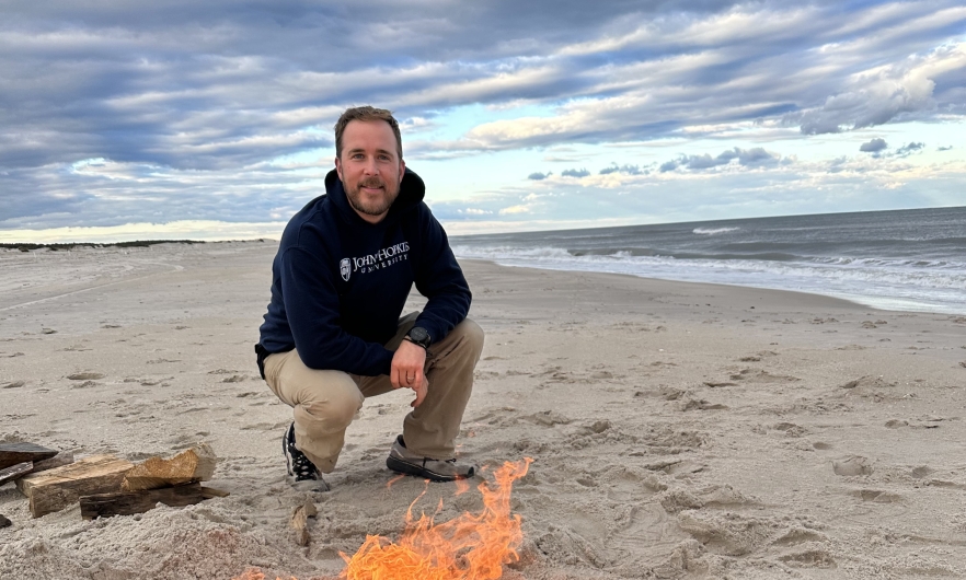 man kneeling on beach