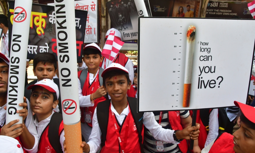 Children hold signs and giant paper cigarettes emblazoned with &quot;No Smoking&quot; to raise awareness of the harms caused by tobacco products on World No Tobacco Day. Mumbai, India, May 31, 2022. 