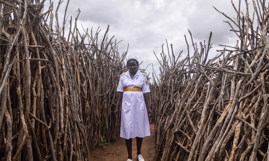 Akol Anna Grace, an assistant nursing officer of Kopoth Health Centre, poses between houses during a home visit in Kopoth, Karamoja region, Uganda, on May 25, 2022. Badru Katumba/AFP via Getty