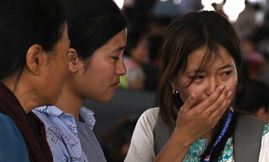 A woman cries as she waits at the Imphal airport to flee ethnic violence in the northeastern Indian state of Manipur on May 7, 2023. 