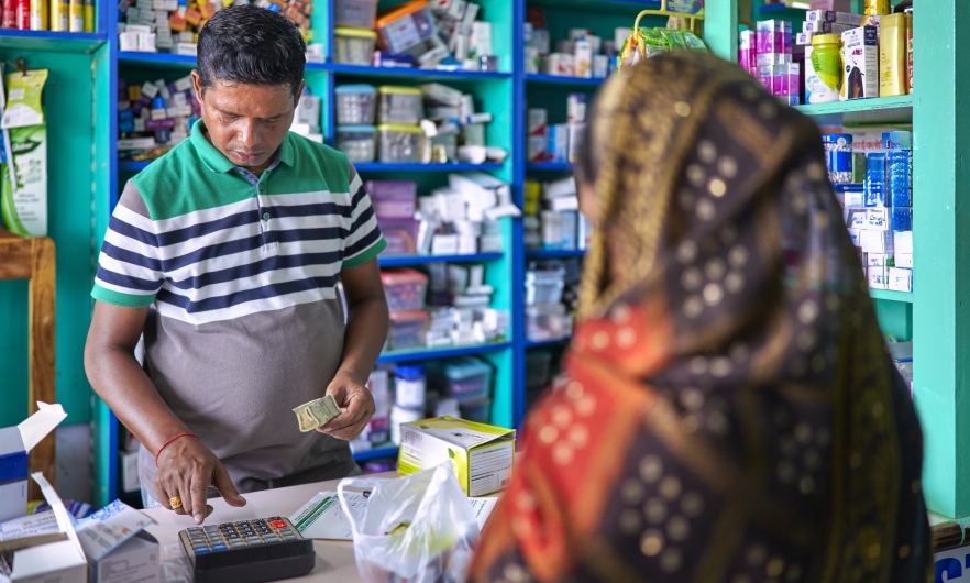 A pharmacist attends to a customer in an Indian pharmacy.