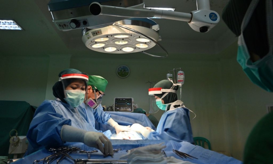 An obstetric team performs a caesarean section delivery at the RSIA Tambak maternity clinic in Jakarta, Indonesia, May 10, 2020.