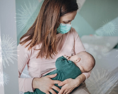 woman breastfeeding baby with mask on