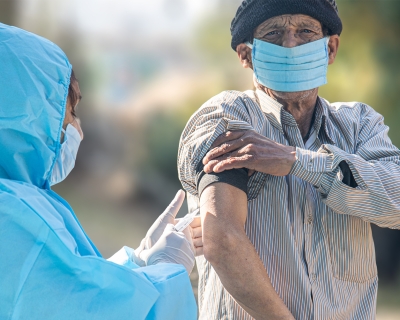 A health care provider gives man a COVID vaccine