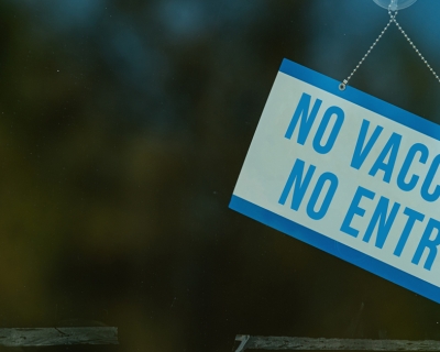 sign on a business's window that says "No vaccine, no entry"