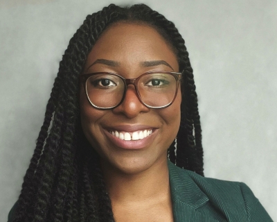 African American lady with long braids, wearing glasses, smiling