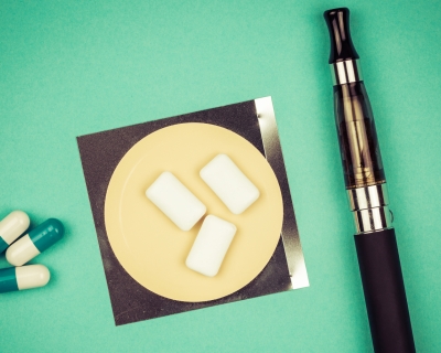 An image of smoking cessation aids, including gum, pills and an e-cigarette.