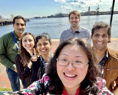 Six MMI students and lab members pose for a selfie near the water in Baltimore's historic Fells Point. 