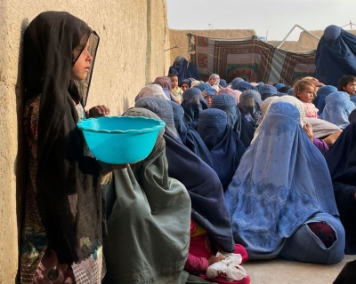  People wait to receive a food donation from the Afterlife foundation during Islam's Holy fasting month of Ramadan in Kandahar