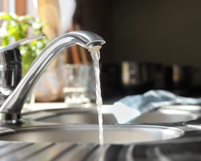 photo of a kitchen faucet with water running