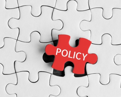 A red puzzle piece labeled policy is slotted into the last empty space of an otherwise complete, white puzzle piece grid.