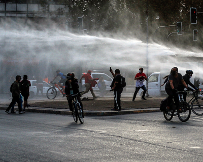 Demonstrators, wearing face masks due to COVID-19, clash with riot police during a protest against President Sebastian Pinera&#039;s government in Santiago, Chile on April 27, 2020. 