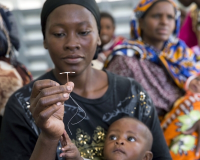 A woman holds up a contraceptive implant during Marie Stopes mobile clinical outreach team visit to a hospital in Rabai, Kenya. June 16, 2014.