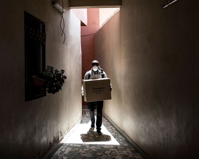 A worker carries a box of protective masks, made from a 3D printing machine, to be delivered emergency workers on the frontline of the COVID-19 coronavirus outbreak in Dakar, Senegal, on April 16, 2020. Image: John Wessels/AFP/Getty