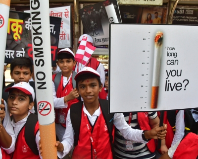 Children hold signs and giant paper cigarettes emblazoned with &quot;No Smoking&quot; to raise awareness of the harms caused by tobacco products on World No Tobacco Day. Mumbai, India, May 31, 2022. 