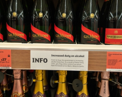 A notice is posted about a rise in duty for alcoholic beverages, between two rows of champagne bottles on store shelves, August 4, 2023 at a Sainsbury&#039;s Market in London, England. Robert Nickelsberg/Getty