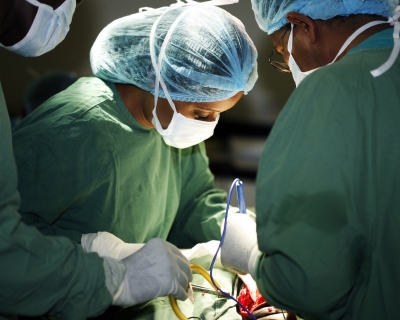 Closeup of a surgeon in green scrubs and her assistants operating on a patient. Universal Images Group Getty