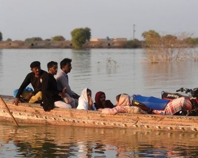 Internally displaced people use a boat to cross a flooded area at Dadu in Sindh province, Pakistan. October 27, 2022. Asif Hassan/AFP via Getty Images