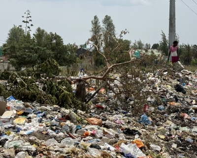 A girl walks among the mountains of waste in Garden Compound.