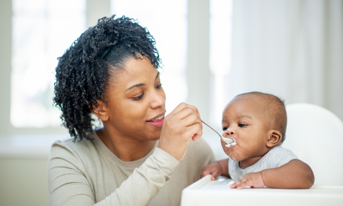 A  baby boy in his highchair as his Mother feeds him