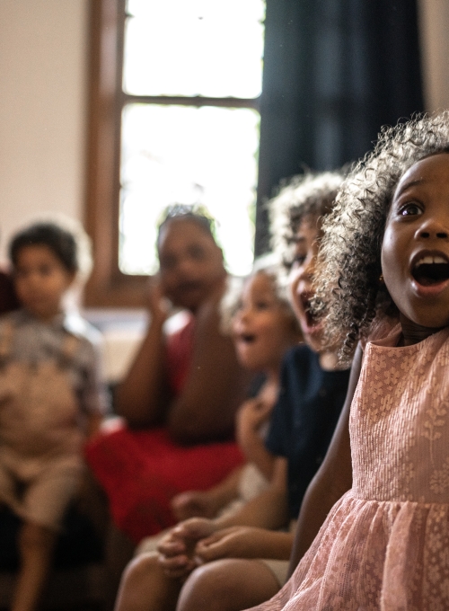 Girl with happy surprised look sitting with group of people