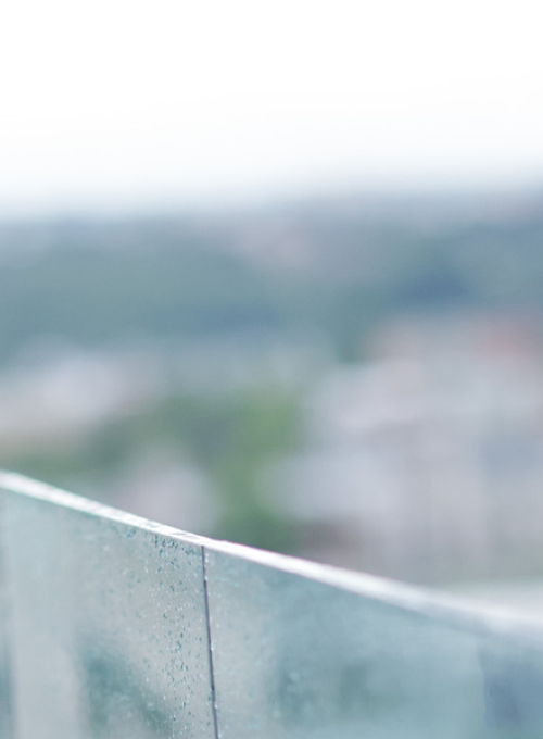 Smiling student on a balcony overlooking a city