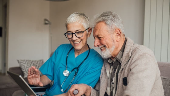 A medical provider reviewing health information on a laptop with a patient.