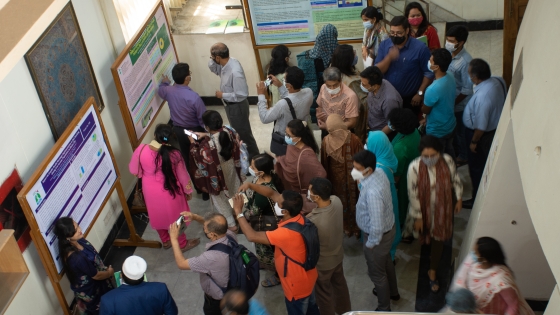 Attendees at the 2021 Bangladesh Tobacco Control Research Network Dissemination Conference look at posters from grantees.